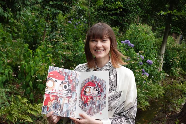 Erica Ward holds her artwork in a park in Tokyo