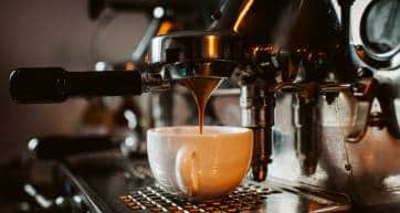 espresso machine pouring coffee into cups