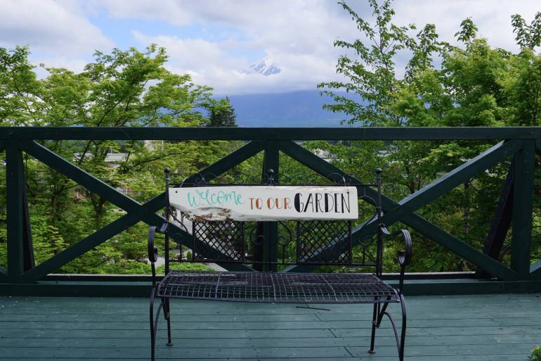 在看台上有張長木椅供遊人拍照，後面一半的富士山被雲霧掩蓋