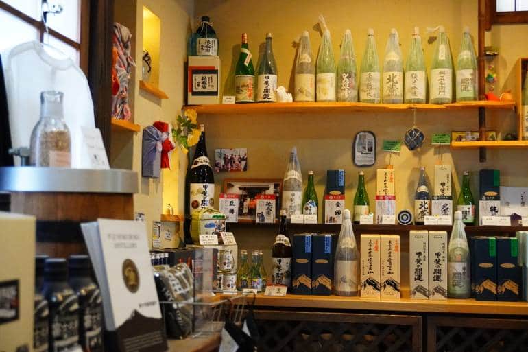 在河口湖的井出清酒釀造廠內，在黃燈底下的清酒樽排列成一行又一行