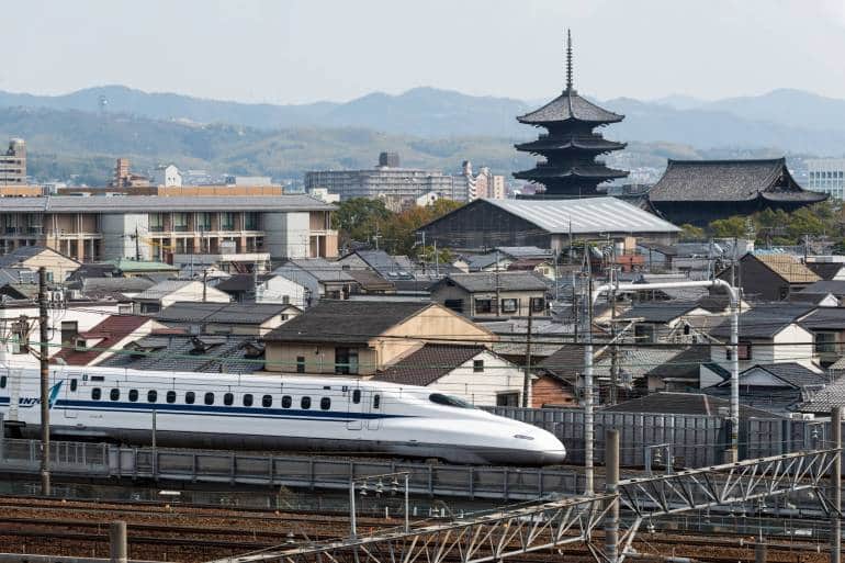 shinkansen traveling through a Japanese city