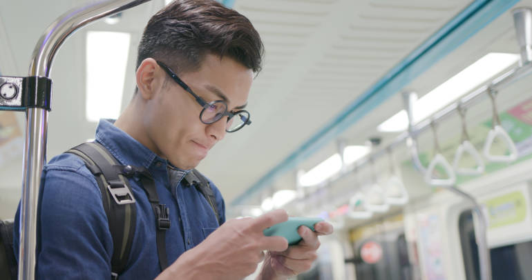 男子在火車上玩電話